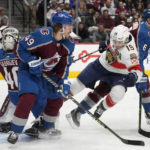 
              Florida Panthers left wing Matthew Tkachuk, front center, tumbles to the ice while driving between Colorado Avalanche defenseman Samuel Girard, front left, and defenseman Erik Johnson to put the puck on goaltender Alexandar Georgiev, back, in the second period of an NHL hockey game Tuesday, Jan. 10, 2023, in Denver. (AP Photo/David Zalubowski)
            