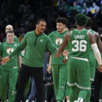 
              Boston Celtics interim head coach Joe Mazzulla, center, celebrates with guard Marcus Smart (36) after their team scored in the second half of an NBA basketball game against the Golden State Warriors, Thursday, Jan. 19, 2023, in Boston. (AP Photo/Steven Senne)
            