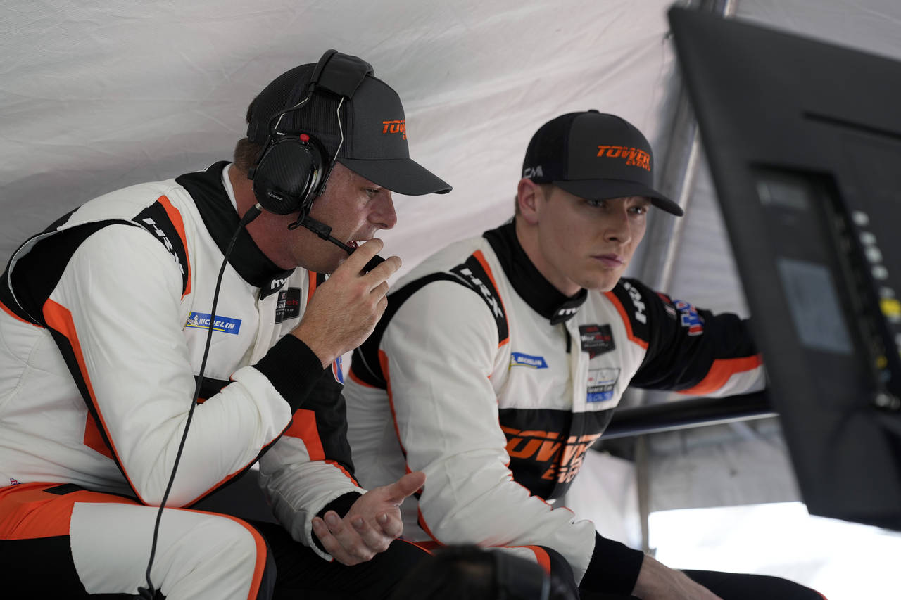 Scott McLaughlin, left, of New Zealand and Josef Newgarden look over a monitor in their pit stall d...