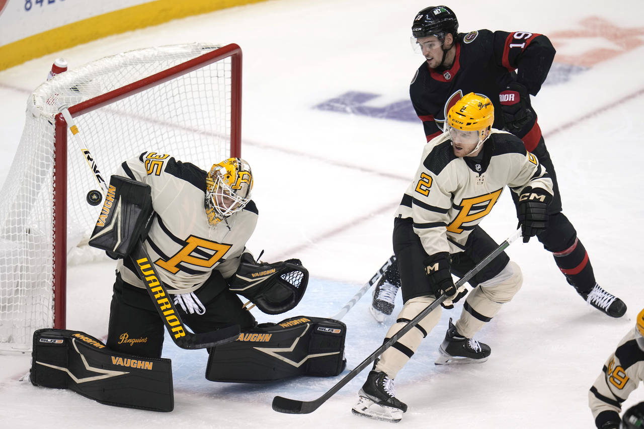 Pittsburgh Penguins goaltender Tristan Jarry (35) blocks a shot with Chad Ruhwedel (2) defending ag...