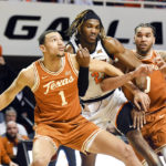 
              Texas forward Dylan Disu (1) and forward Timmy Allen (0) hold back Oklahoma State forward Tyreek Smith (23) following a free throw during the second half of an NCAA college basketball game Saturday, Jan. 7, 2023, in Stillwater, Okla. Texas defeated Oklahoma State 56-46. (AP Photo/Brody Schmidt)
            