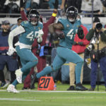 
              Jacksonville Jaguars linebacker Josh Allen (41) returns a fumble for a touchdown as defensive end Arden Key (49) covers in the second half of an NFL football game against the Tennessee Titans, Saturday, Jan. 7, 2023, in Jacksonville, Fla. (AP Photo/Phelan M. Ebenhack)
            