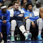 
              Dallas Mavericks guard Luka Doncic, center left, sits on the bench with forward Christian Wood, center right, and forward Tim Hardaway Jr. during the second half of the team's NBA basketball game against the Boston Celtics in Dallas, Thursday, Jan. 5, 2023. (AP Photo/LM Otero)
            
