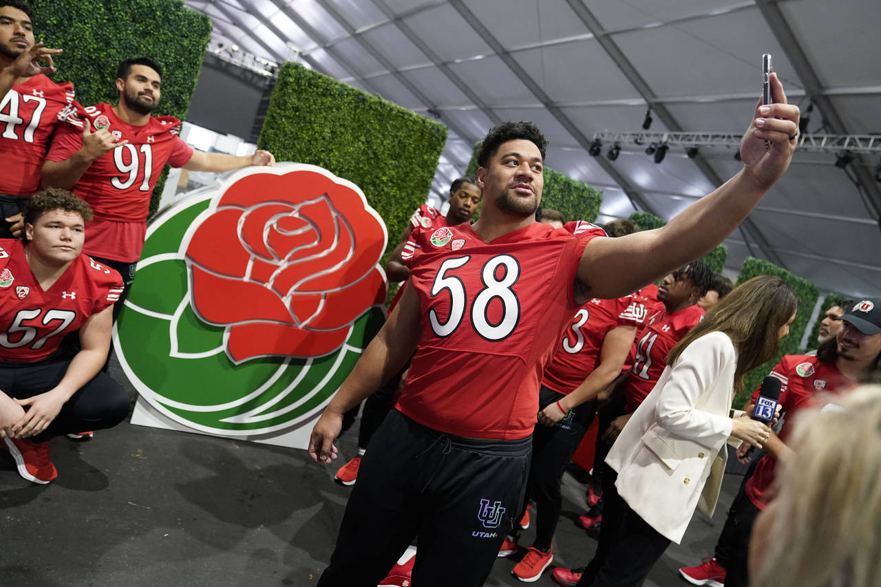 Utah defensive tackle Junior Tafuna (58) takes a selfie with teammates in from the of the logo duri...