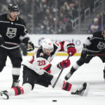 
              New Jersey Devils center Michael McLeod, center, falls while under pressure from Los Angeles Kings left wing Kevin Fiala, left, and center Blake Lizotte during the first period of an NHL hockey game Saturday, Jan. 14, 2023, in Los Angeles. (AP Photo/Mark J. Terrill)
            