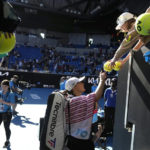 
              Iga Swiatek of Poland signs autographs after defeating Cristina Bucsa of Spain in their third round match at the Australian Open tennis championship in Melbourne, Australia, Friday, Jan. 20, 2023. (AP Photo/Dita Alangkara)
            