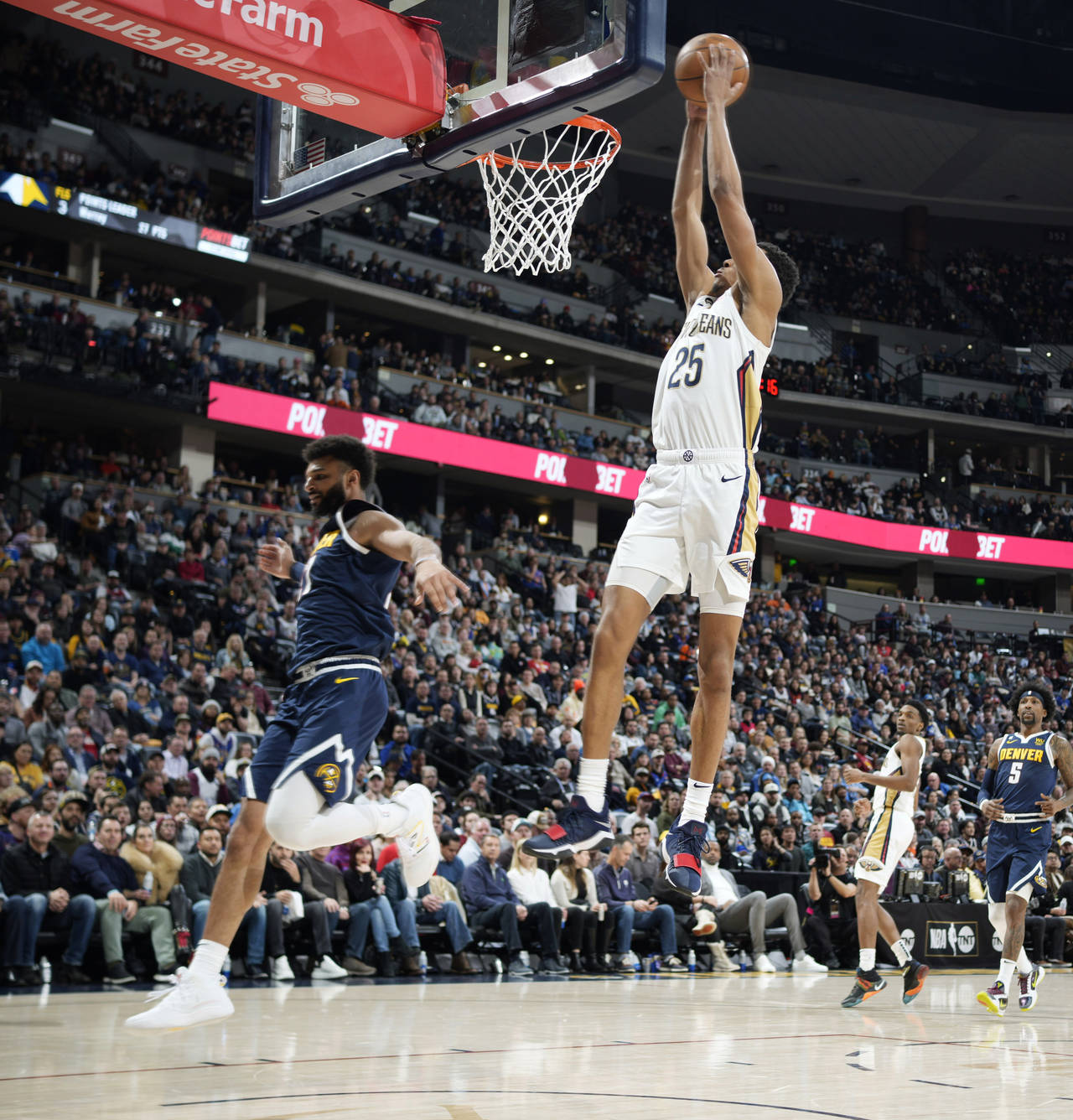 New Orleans Pelicans guard Trey Murphy III, right, goes up for a basket as Denver Nuggets guard Jam...