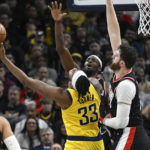 
              Indiana Pacers center Myles Turner (33) shoots in front of Portland Trail Blazers forward Jerami Grant, second from right, and center Jusuf Nurkic, right, during the second half of an NBA basketball game, Friday, Jan. 6, 2023, in Indianapolis. (AP Photo/Marc Lebryk)
            