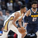 
              New Orleans Pelicans guard CJ McCollum, front, looks to pass the ball as Denver Nuggets guard Jamal Murray defends in the first half of an NBA basketball game Tuesday, Jan. 31, 2023, in Denver. (AP Photo/David Zalubowski)
            