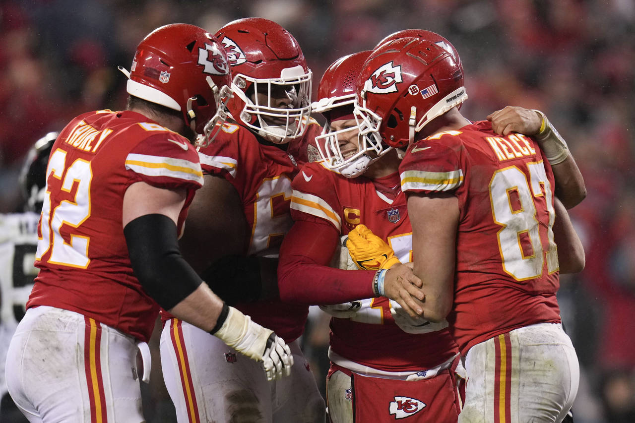 Kansas City Chiefs quarterback Patrick Mahomes (15) is helped by teammates after a play against the...