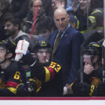 
              Vancouver Canucks coach Rick Tocchet, back, stands behind Ilya Mikheyev, Bo Horvat and Brock Boeser, from left, during the first period of the team's NHL hockey game against the Chicago Blackhawks on Tuesday, Jan. 24, 2023, in Vancouver, British Columbia. (Darryl Dyck/The Canadian Press via AP)
            