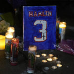 
              A painting that shows the number of Buffalo Bills' Damar Hamlin is illuminated by candles during a prayer vigil outside University of Cincinnati Medical Center, Tuesday, Jan. 3, 2023, in Cincinnati. Hamlin was taken to the hospital after collapsing on the field during an NFL football game against the Cincinnati Bengals on Monday night. (AP Photo/Darron Cummings)
            