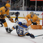 
              St. Louis Blues' Jake Neighbours (63) reaches for a loose puck as Nashville Predators goaltender Juuse Saros (74) and Matt Duchene (95) watch during the second period of an NHL hockey game Thursday, Jan. 19, 2023, in St. Louis. (AP Photo/Jeff Roberson)
            