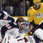
              The mask of Columbus Blue Jackets goaltender Daniil Tarasov (40) comes off after he blocked a shot by the Nashville Predators during the second period of an NHL hockey game Tuesday, Jan. 17, 2023, in Nashville, Tenn. (AP Photo/Mark Zaleski)
            