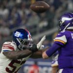 
              Minnesota Vikings' Kirk Cousins thorws as he's pressured by New York Giants' Jarrad Davis during the second half of an NFL wild card football game Sunday, Jan. 15, 2023, in Minneapolis. (AP Photo/Charlie Neibergall)
            