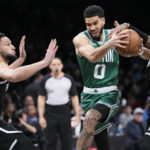 
              Brooklyn Nets guard Ben Simmons (10) and guard Kyrie Irving guard Boston Celtics forward Jayson Tatum (0) during the first half of an NBA basketball game Thursday, Jan. 12, 2023, in New York. (AP Photo/Mary Altaffer)
            