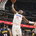 
              Los Angeles Clippers guard Terance Mann dunks between Denver Nuggets forward Bruce Brown, left, and center Nikola Jokic during the second half of an NBA basketball game Thursday, Jan. 5, 2023, in Denver. (AP Photo/David Zalubowski)
            