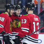 
              Chicago Blackhawks' Patrick Kane, from left, Tyler Johnson and Max Domi celebrate after a goal by Johnson during the third period of an NHL hockey game against the Philadelphia Flyers, Thursday, Jan. 19, 2023, in Philadelphia. (AP Photo/Matt Slocum)
            
