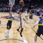 
              Miami Heat forward Caleb Martin (16) goes to the basket between New Orleans Pelicans guard CJ McCollum (3) and center Jonas Valanciunas (17) in the first half of an NBA basketball game in New Orleans, Wednesday, Jan. 18, 2023. (AP Photo/Gerald Herbert)
            