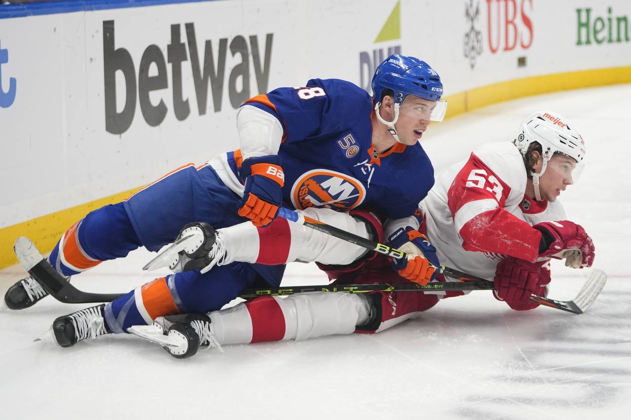 New York Islanders' Anthony Beauvillier (18) and Detroit Red Wings' Moritz Seider (53) fall down wh...