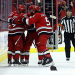 
              Carolina Hurricanes surround Seth Jarvis (24) to celebrate his hat trick goal during the third period of an NHL hockey game against the Montreal Canadiens in Raleigh, N.C., Thursday, Feb. 16, 2023. (AP Photo/Karl B DeBlaker)
            