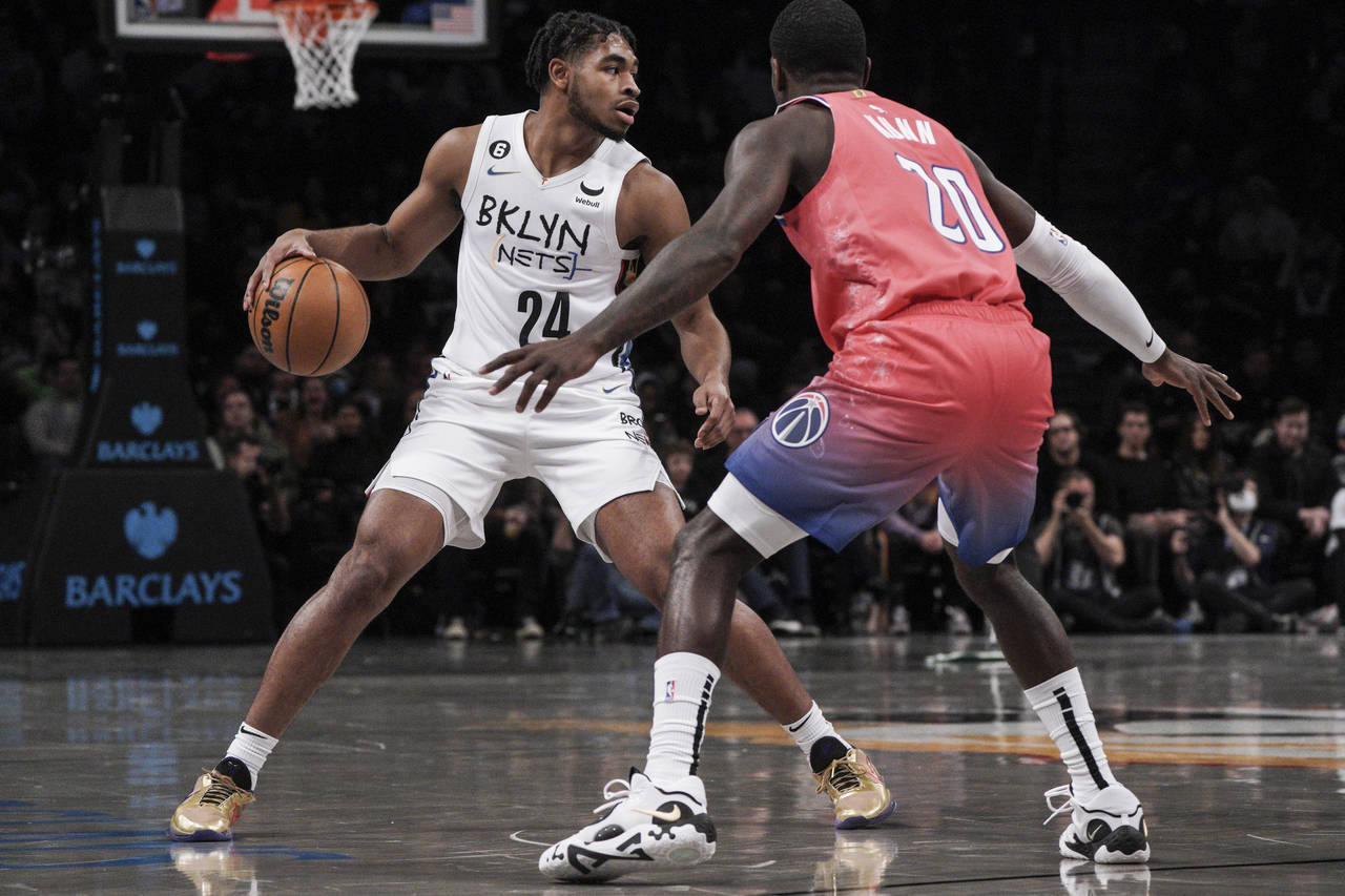 Brooklyn Nets guard Cam Thomas, left, drives to the basket against Washington Wizards Kendrick Nunn...