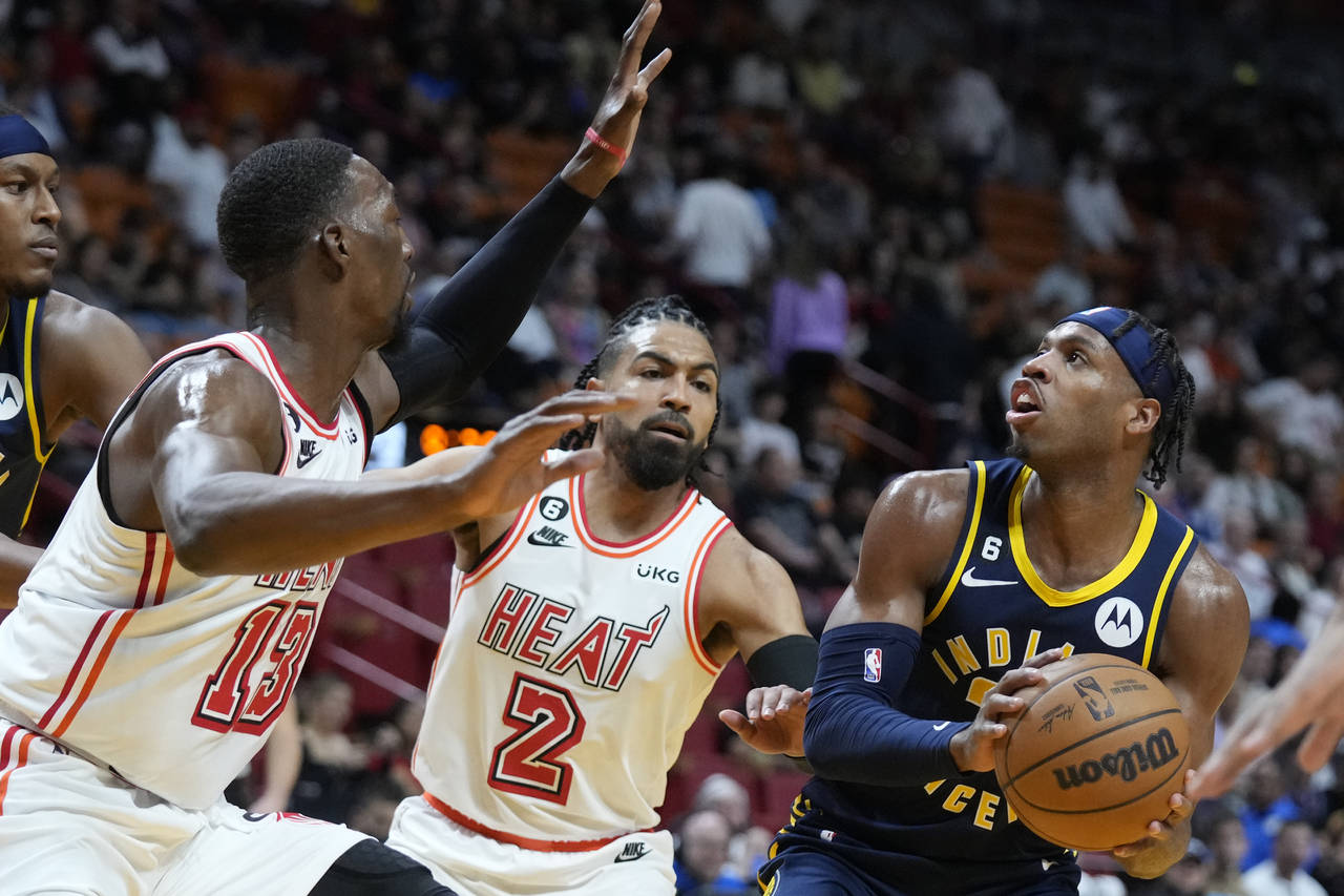 Indiana Pacers guard Buddy Hield, right, looks for an opening past Miami Heat center Bam Adebayo (1...