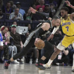 
              Memphis Grizzlies Dillon Brooks pushes past LosAngeles Lakers Troy Brown Jr. (7) in the first half of an NBA basketball game, Tuesday, Feb. 28, 2023, in Memphis, Tenn. (AP Photo/Karen Pulfer Focht)
            
