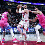 
              Chicago Bulls guard Zach LaVine, center, drives as Washington Wizards guard Delon Wright, left, and forward Deni Avdija guard during the first half of an NBA basketball game in Chicago, Sunday, Feb. 26, 2023. (AP Photo/Nam Y. Huh)
            