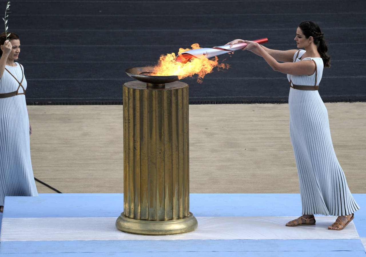 FILE - Greek actress Xanthi Georgiou, playing the role of High Priestess, lights the torch with the...