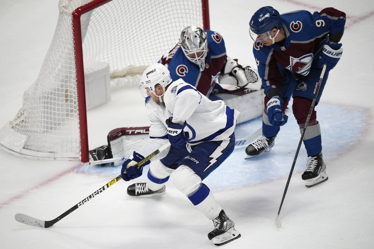 Tampa Bay Lightning center Steven Stamkos, front, directs a shot at Colorado Avalanche goaltender A...