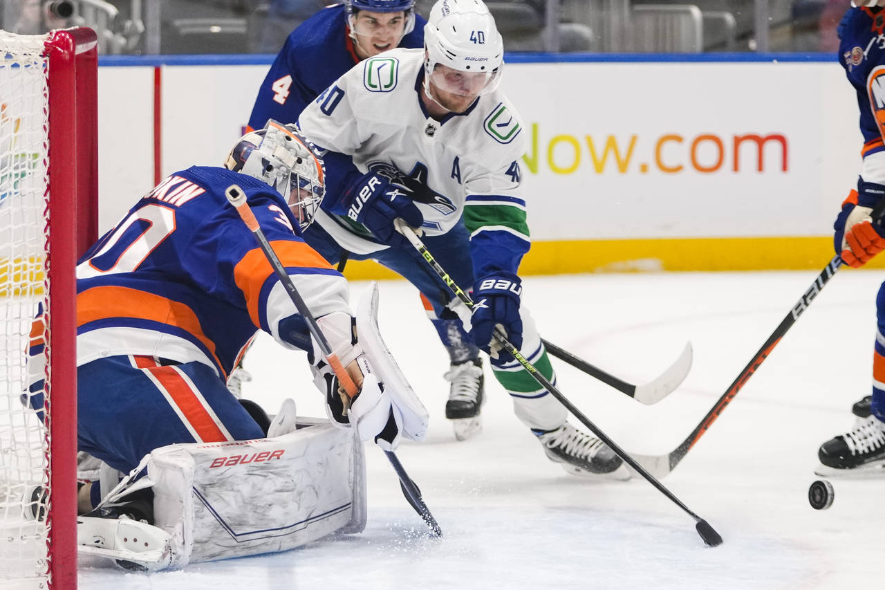 New York Islanders goaltender Ilya Sorokin (30) stops a shot by Vancouver Canucks' Elias Pettersson...