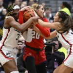 
              UConn's Aaliyah Edwards, left, and Caroline Ducharme, right, pressure St. John's Rayven Peeples, center, in the first half of an NCAA college basketball game, Tuesday, Feb. 21, 2023, in Hartford, Conn. (AP Photo/Jessica Hill)
            
