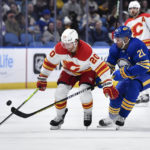 
              Buffalo Sabres right wing Kyle Okposo, right, tips the puck away from Calgary Flames center Blake Coleman during the first period of an NHL hockey game in Buffalo, N.Y., Saturday, Feb. 11, 2023. (AP Photo/Adrian Kraus)
            