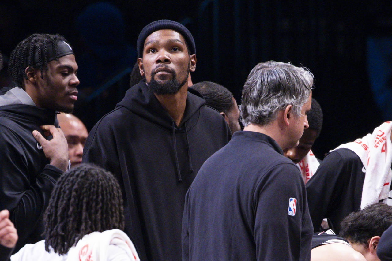 Brooklyn Nets forward Kevin Durant, center, looks on from the bench during the second half of an NB...