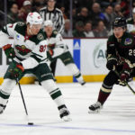 
              Minnesota Wild left wing Kirill Kaprizov (97) skates with the puck away from Arizona Coyotes center Barrett Hayton in the first period during an NHL hockey game, Monday, Feb. 6, 2023, in Tempe, Ariz. (AP Photo/Rick Scuteri)
            