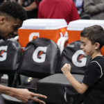 
              Milwaukee Bucks forward Giannis Antetokounmpo, left, plays Rock Paper Scissors with a young fan to see if the fan gets his shoes after an NBA basketball game between the Los Angeles Clippers and the Bucks Friday, Feb. 10, 2023, in Los Angeles. (AP Photo/Mark J. Terrill)
            