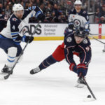 
              Columbus Blue Jackets forward Kent Johnson, right, reaches for the puck in front of Winnipeg Jets defenseman Neal Pionk (4) during the second period of an NHL hockey game in Columbus, Ohio, Thursday, Feb. 16, 2023. (AP Photo/Paul Vernon)
            