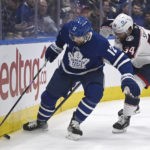 
              Toronto Maple Leafs left winger Zach Aston-Reese (12) battles for the puck against Columbus Blue Jackets center Cole Sillinger (34) during second-period NHL hockey game action  Saturday, Feb. 11, 2023, in Toronto. (Jon Blacker/The Canadian Press via AP)
            