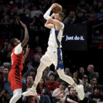 
              Washington Wizards center Kristaps Porzingis, right, goes up for a shot in Portland Trail Blazers forward Cam Reddish, left, during the first half of an NBA basketball game in Portland, Ore., Tuesday, Feb. 14, 2023. (AP Photo/Steve Dykes)
            