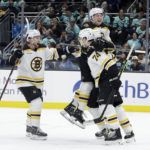 
              Boston Bruins defenseman Matt Grzelcyk, left, Charlie McAvoy, top, and a teammate celebrate a goal by left wing Jake DeBrusk (74) against the Seattle Kraken during the third period of an NHL hockey game Thursday, Feb. 23, 2023, in Seattle. The Bruins won 6-5. (AP Photo/John Froschauer)
            