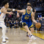 
              Golden State Warriors guard Ty Jerome (10) drives past Oklahoma City Thunder guard Tre Mann (23) during the first half of an NBA basketball game in San Francisco, Monday, Feb. 6, 2023. (AP Photo/John Hefti)
            