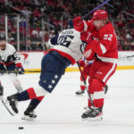 
              Washington Capitals defenseman Dylan McIlrath (25) applies a hit on Detroit Red Wings right wing Jonatan Berggren (52) during the first period of an NHL hockey game, Tuesday, Feb. 21, 2023, in Washington. (AP Photo/Julio Cortez)
            