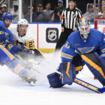 
              St. Louis Blues goaltender Jordan Binnington (50) and Brandon Saad (20) defend the net from the Pittsburgh Penguins' Brock McGinn (23) during the first period of an NHL hockey game, Saturday, Feb. 25, 2023, in St. Louis. (AP Photo/Jeff Le)
            