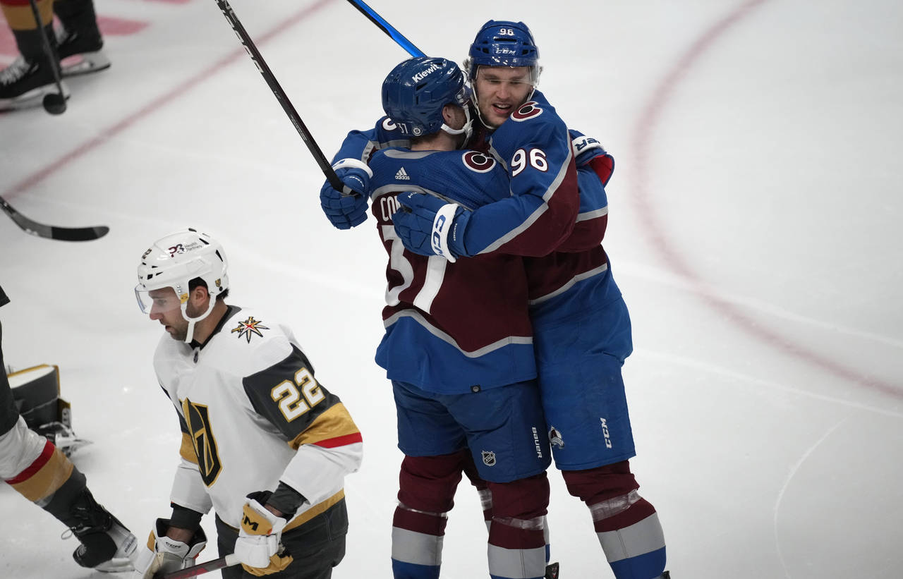 Colorado Avalanche right wing Mikko Rantanen, right, hugs left wing J.T. Compher after scoring as V...