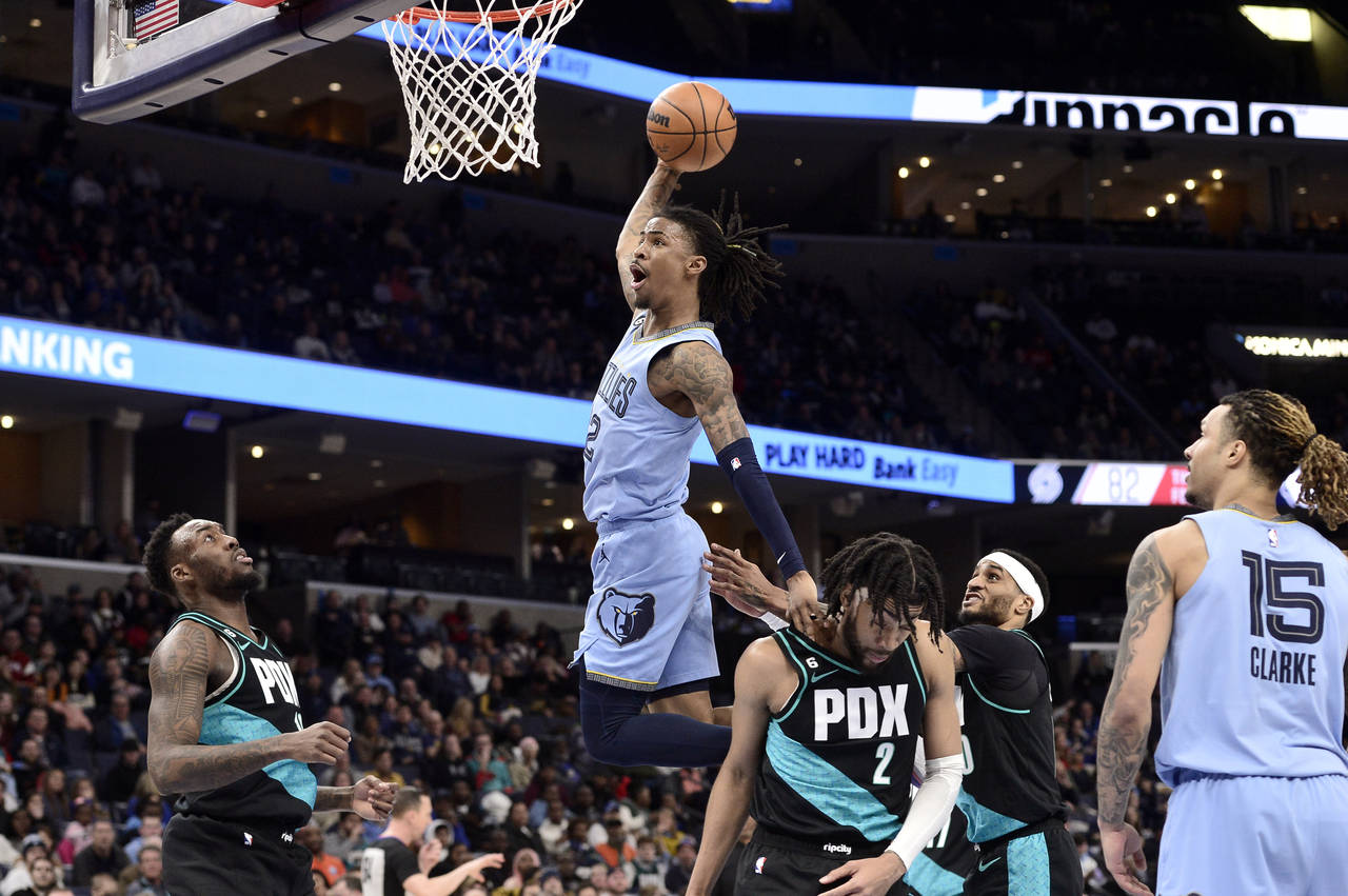 Memphis Grizzlies guard Ja Morant (12) goes up for a dunk over Portland Trail Blazers forward Trend...
