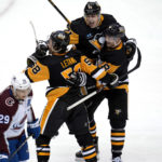 
              Pittsburgh Penguins' Kris Letang (58) celebrates his overtime goal with Evgeni Malkin (71) and Brian Dumoulin (8) as Colorado Avalanche's Nathan MacKinnon (29) skates off the ice, in an NHL hockey game in Pittsburgh, Tuesday, Feb. 7, 2023. (AP Photo/Gene J. Puskar)
            