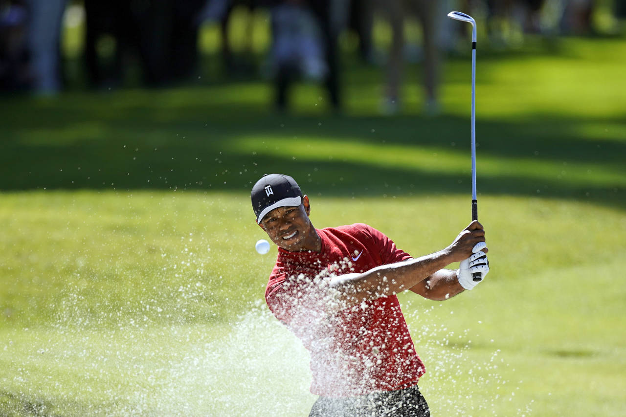 FILE -  Tiger Woods hits out of a greenside bunker on the 17th hole during the final round of the G...