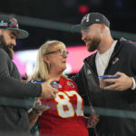 
              Donna Kelce greets her sons, Philadelphia Eagles center Jason Kelce, left, and Kansas City Chiefs tight end Travis Kelce during the NFL football Super Bowl 57 opening night, Monday, Feb. 6, 2023, in Phoenix. The Kansas City Chiefs will play the Philadelphia Eagles on Sunday. (AP Photo/Matt York)
            