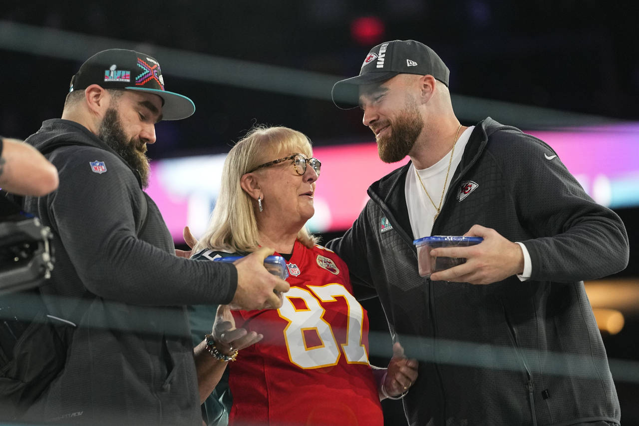 Donna Kelce greets her sons, Philadelphia Eagles center Jason Kelce, left, and Kansas City Chiefs t...
